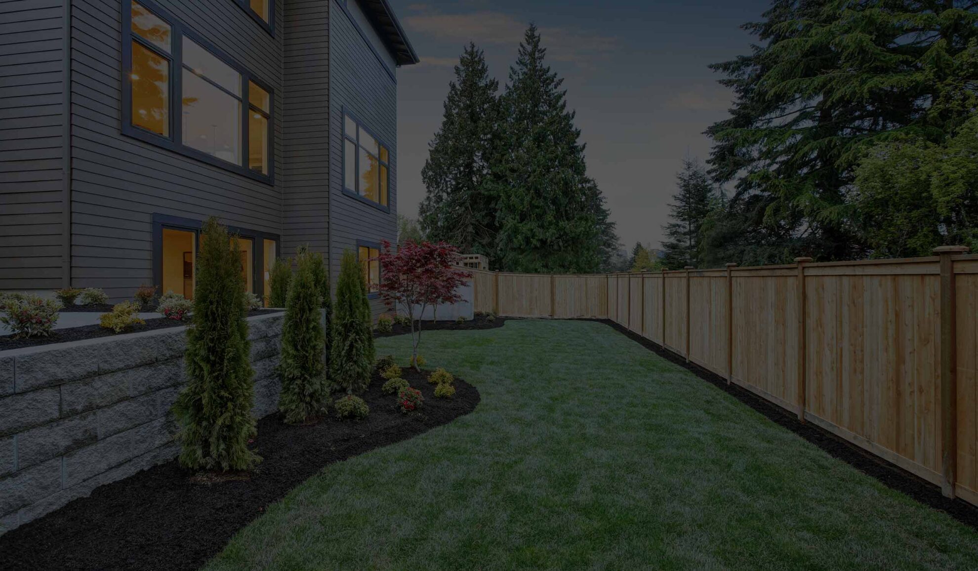 house backyard with landscape design installed and wood fencing at the back overland park ks